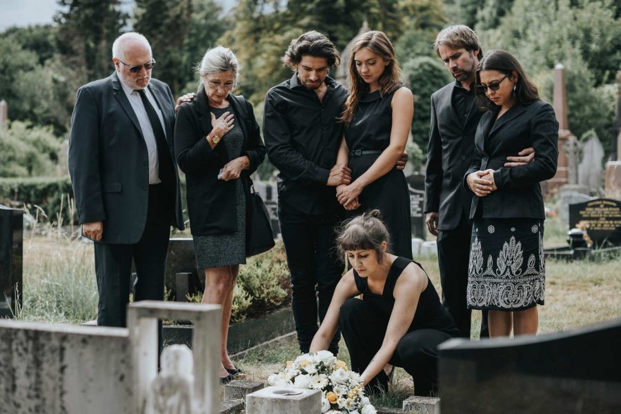 family-laying-flowers-on-the-grave-QKURHPX.jpg